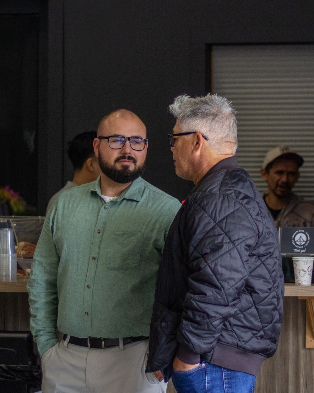 Two men talking at the coffee bar